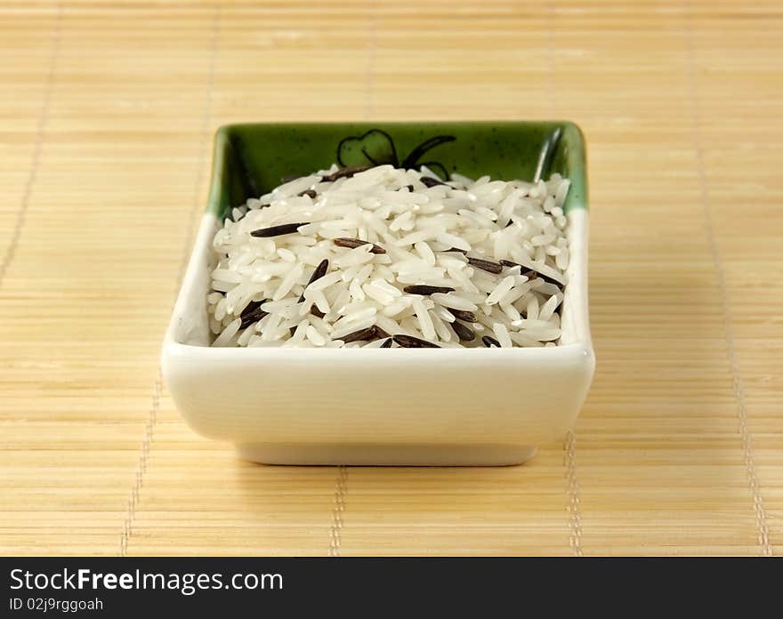 A bowl of mixed rice on a bamboo mat. A bowl of mixed rice on a bamboo mat