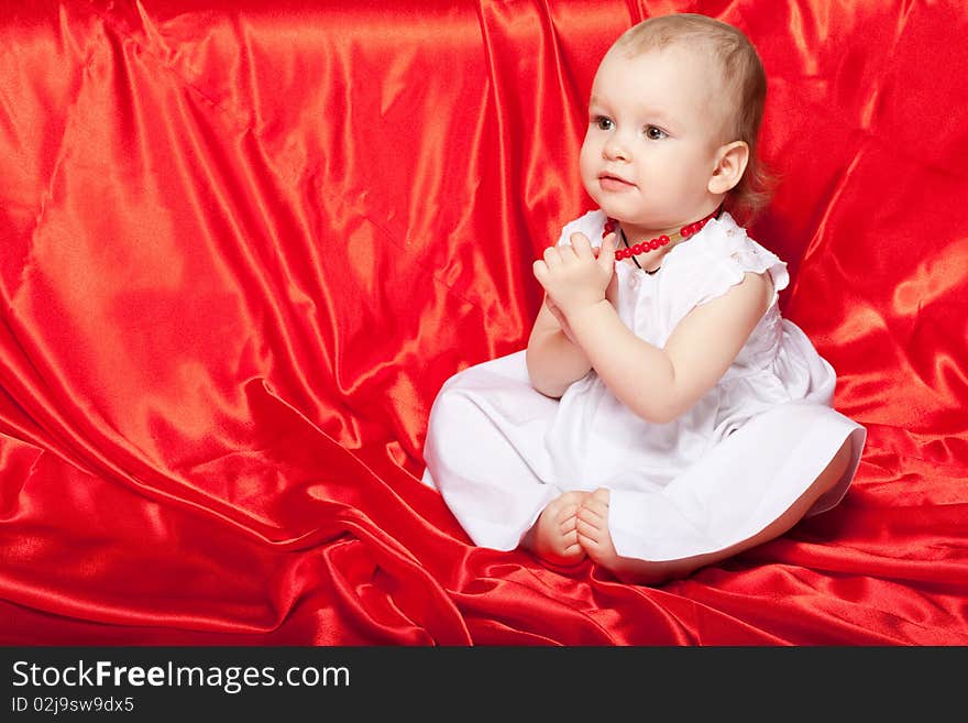 Cute baby sitting on the red silk cloth. Cute baby sitting on the red silk cloth