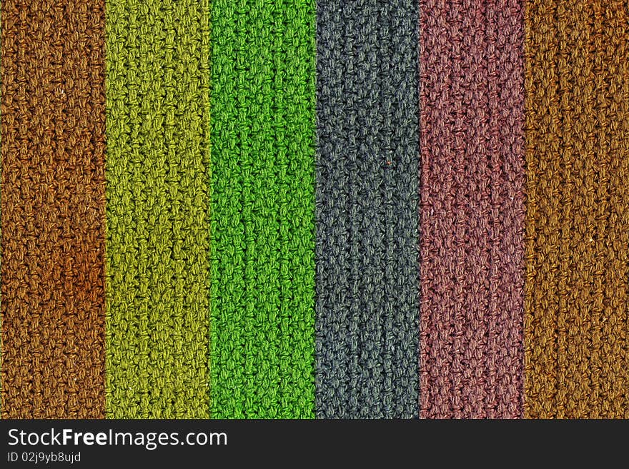 A texture background of a woven wool texture with vertical colored strips. A texture background of a woven wool texture with vertical colored strips.