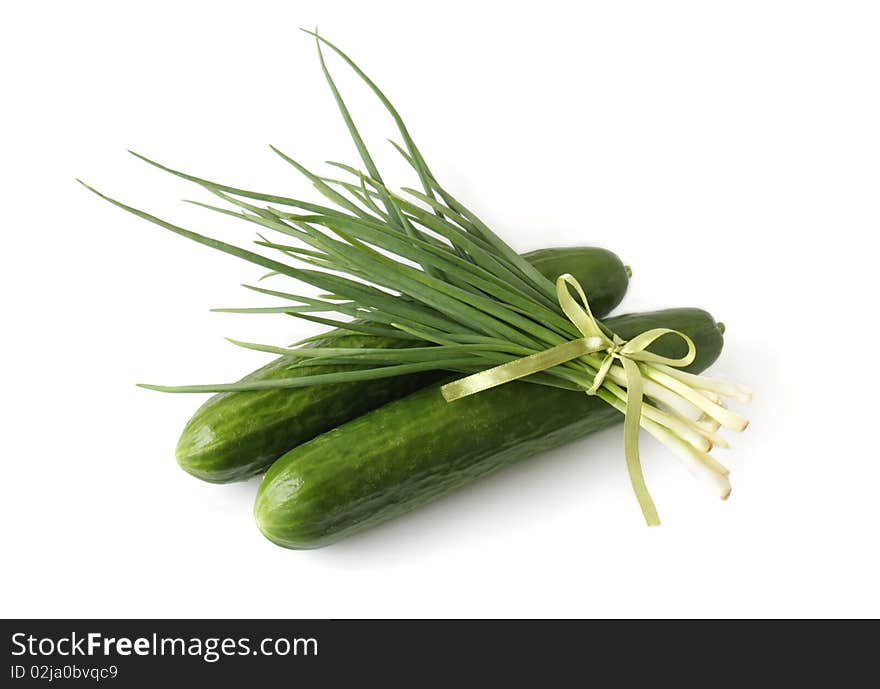 A bunch of green onions and cucumbers on a white background