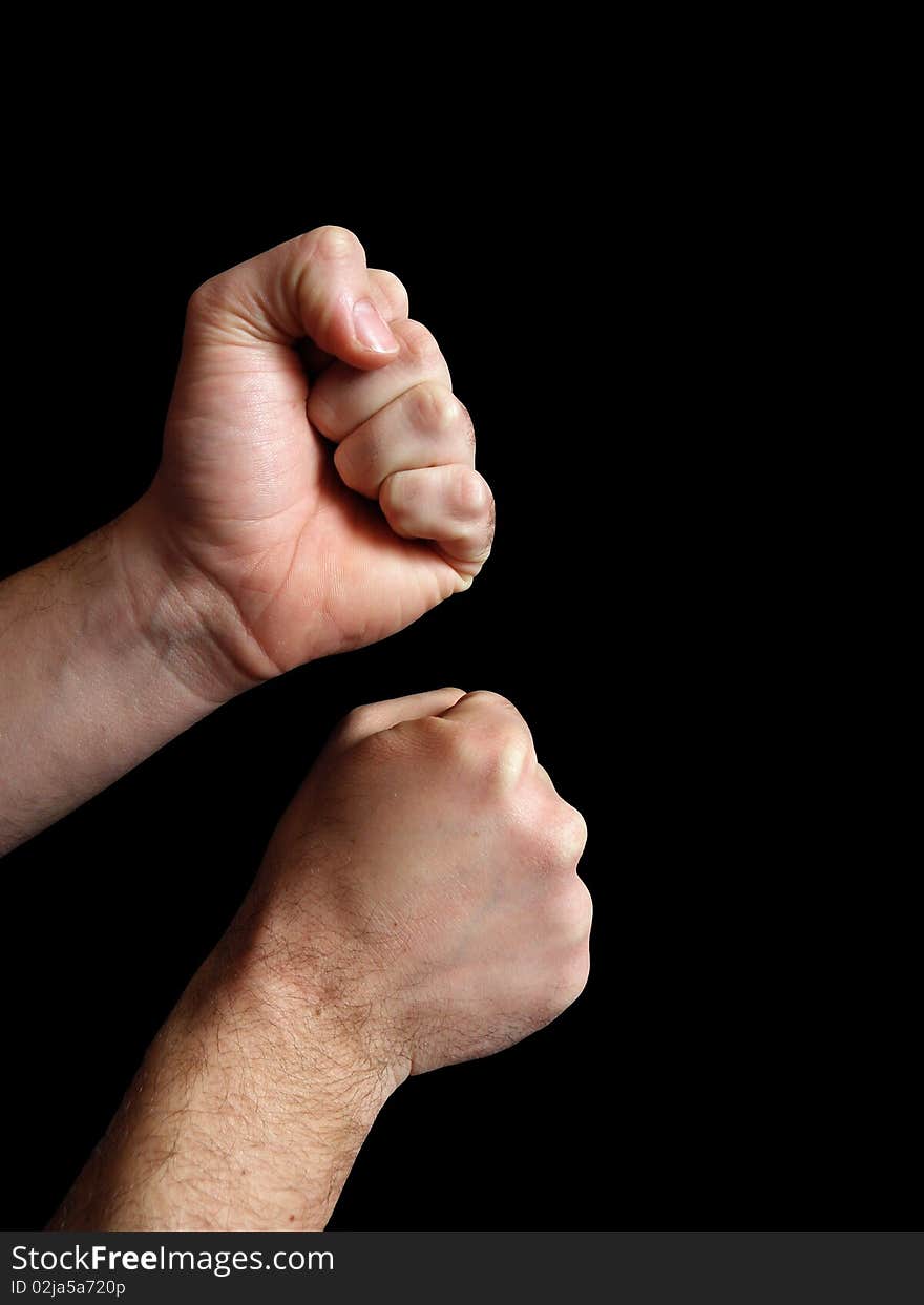 Two men's hands with clenched fists. Present position to start a fight. On a black background.