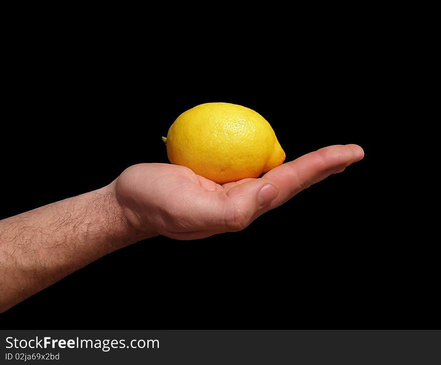 Yellow lemon laid on men's outstretched hand. On a black background. Yellow lemon laid on men's outstretched hand. On a black background.