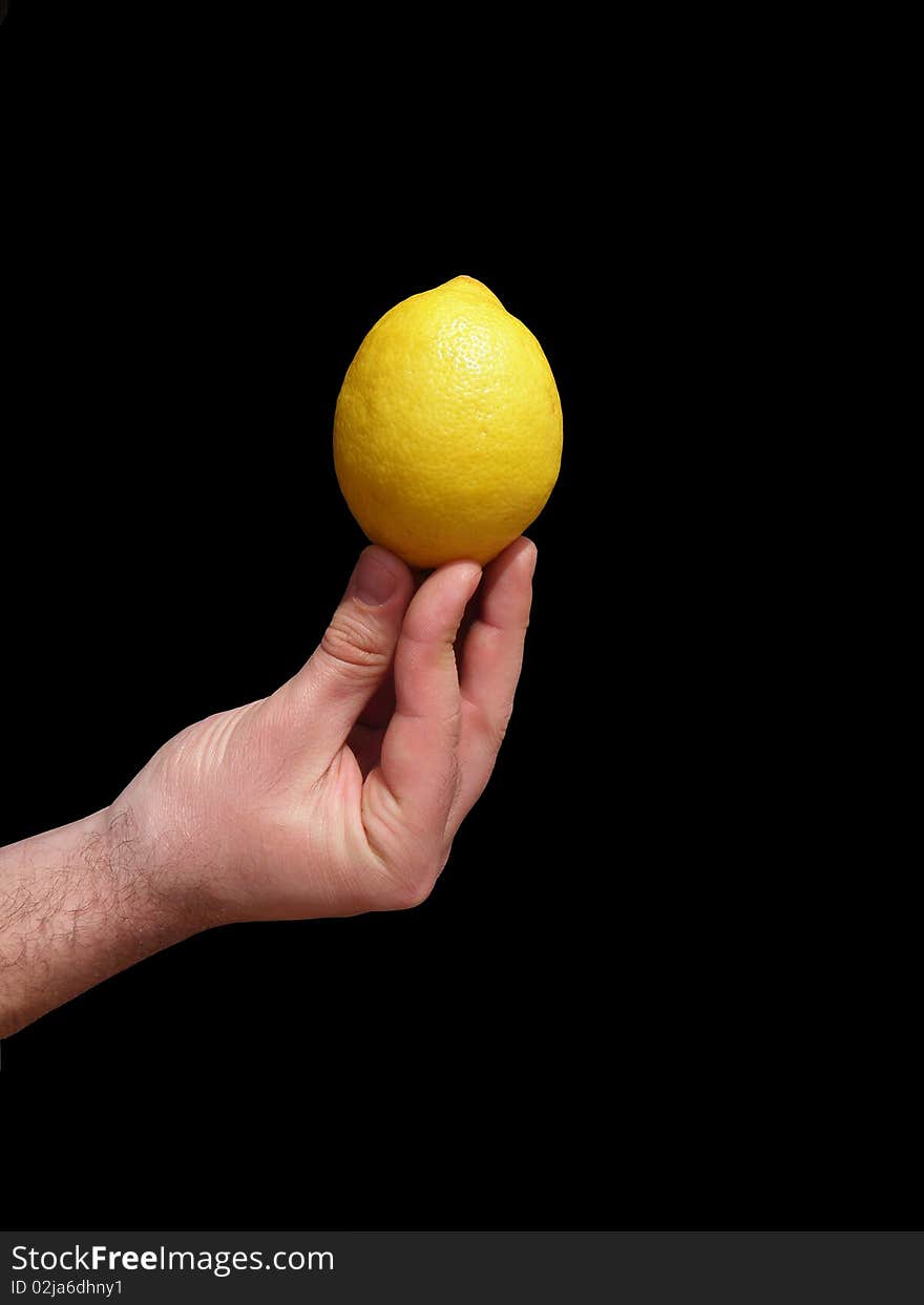 Yellow lemon which holds the men's hand. On a black background.