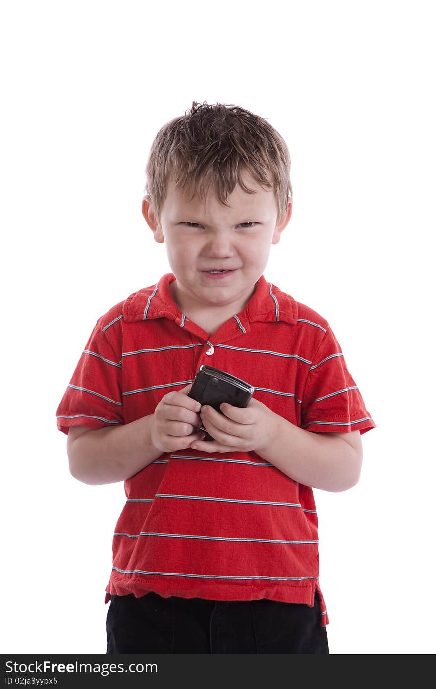 A young boy has a cell phone with a mad expression on his face. A young boy has a cell phone with a mad expression on his face.