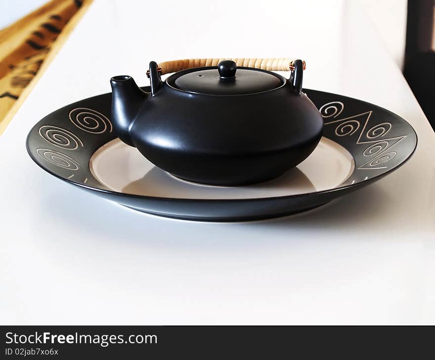 Black ceramic teapot on a tray. Black ceramic teapot on a tray