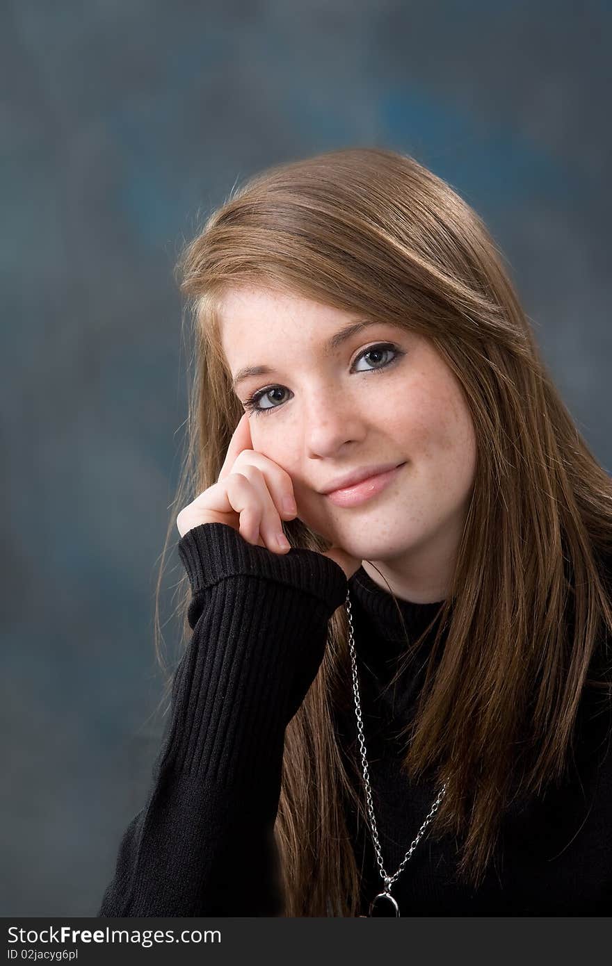 Portrait of pretty young teen age girl on blue background.