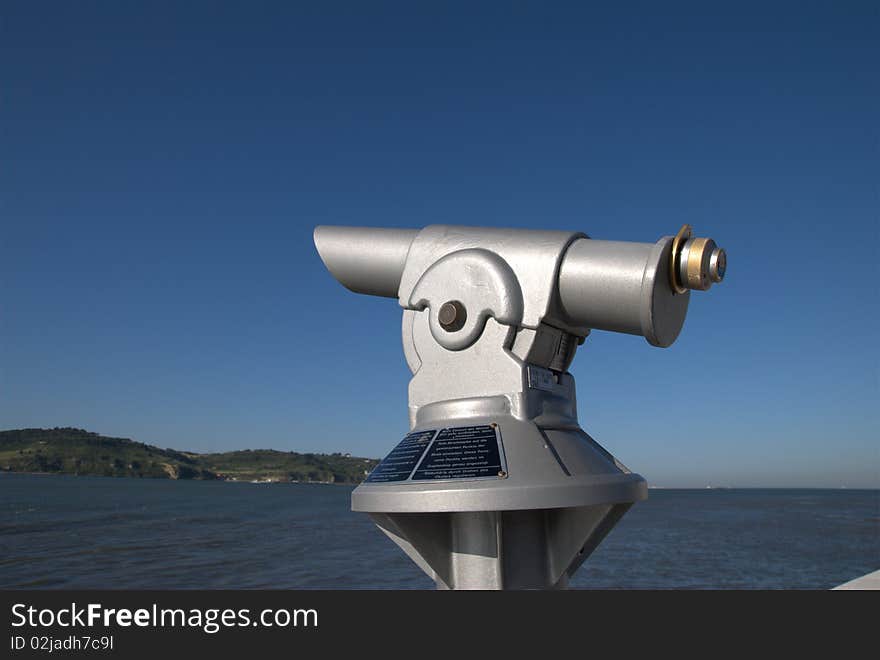 Coin operated public telescope under a blue sky