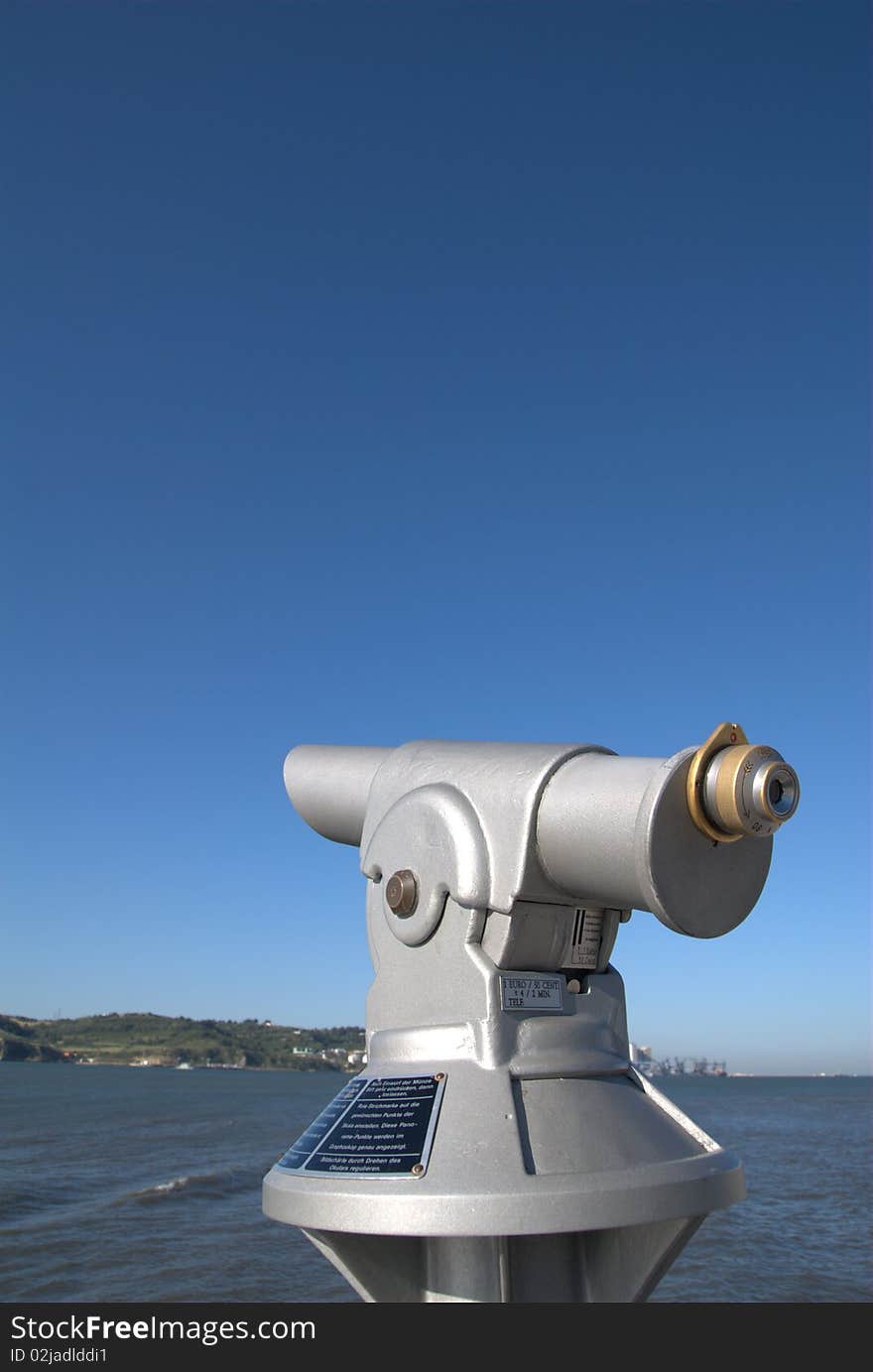 Coin operated public telescope under a blue sky