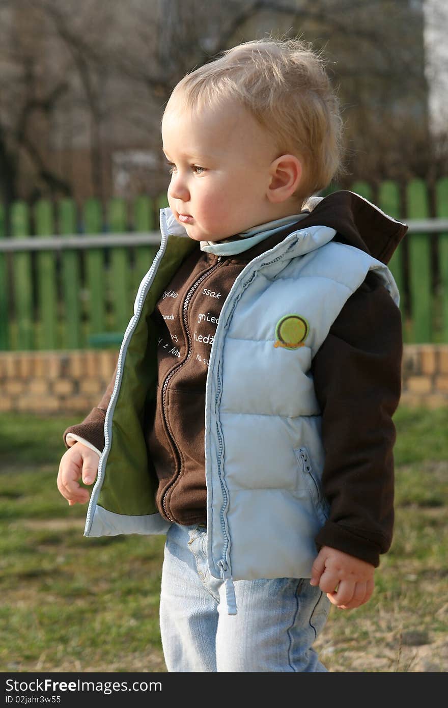 17 months old baby boy is playing outdoor in a sandpit.at a playground. 17 months old baby boy is playing outdoor in a sandpit.at a playground