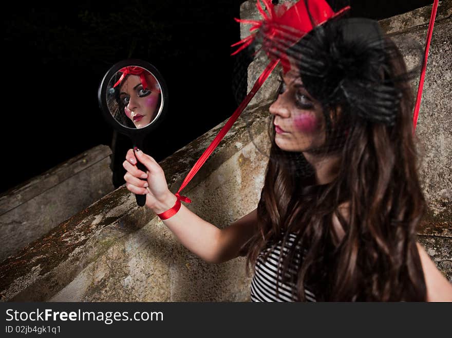 Beautiful girl wearing red hat and striped dress posing as a marionette (puppet on a string)