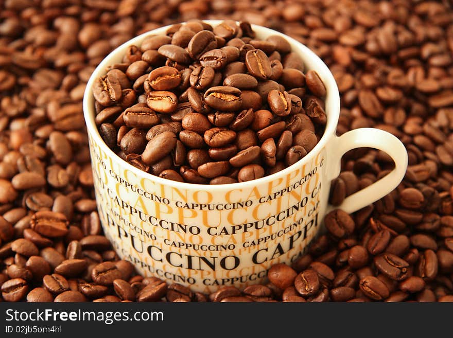 Fresh brown coffee beans in a cappuccino cup