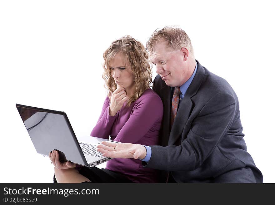 A couple is sitting with a computer and trying to figure out a problem. A couple is sitting with a computer and trying to figure out a problem.