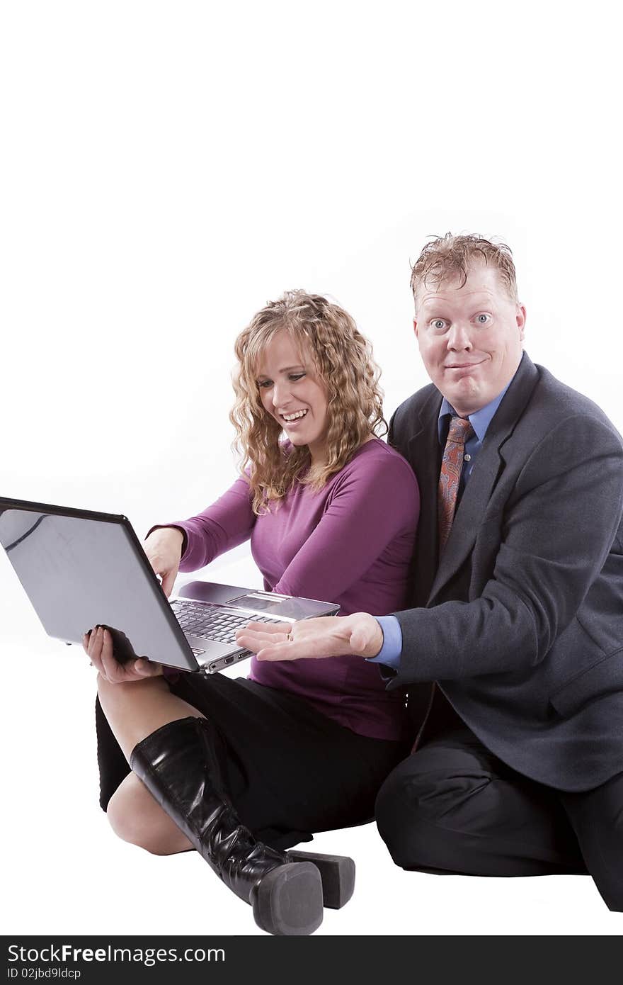 A couple sitting with a computer and happy expressions. A couple sitting with a computer and happy expressions