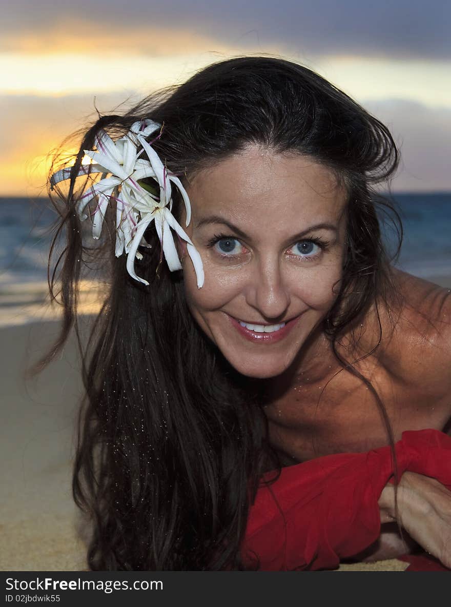 Forty year old woman in red chiffon on the beach in hawaii. Forty year old woman in red chiffon on the beach in hawaii