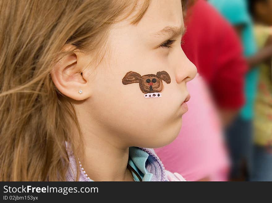 Young girl at a school carnival with her face painted. Young girl at a school carnival with her face painted.