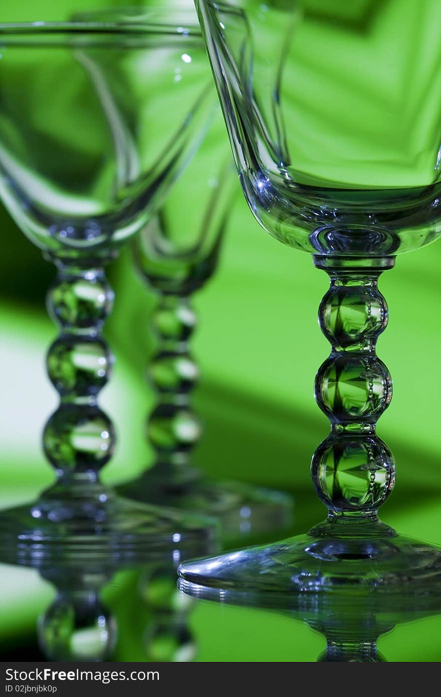 Beautiful wine glasses on abstract green background with detailed focus on front glass. Beautiful wine glasses on abstract green background with detailed focus on front glass