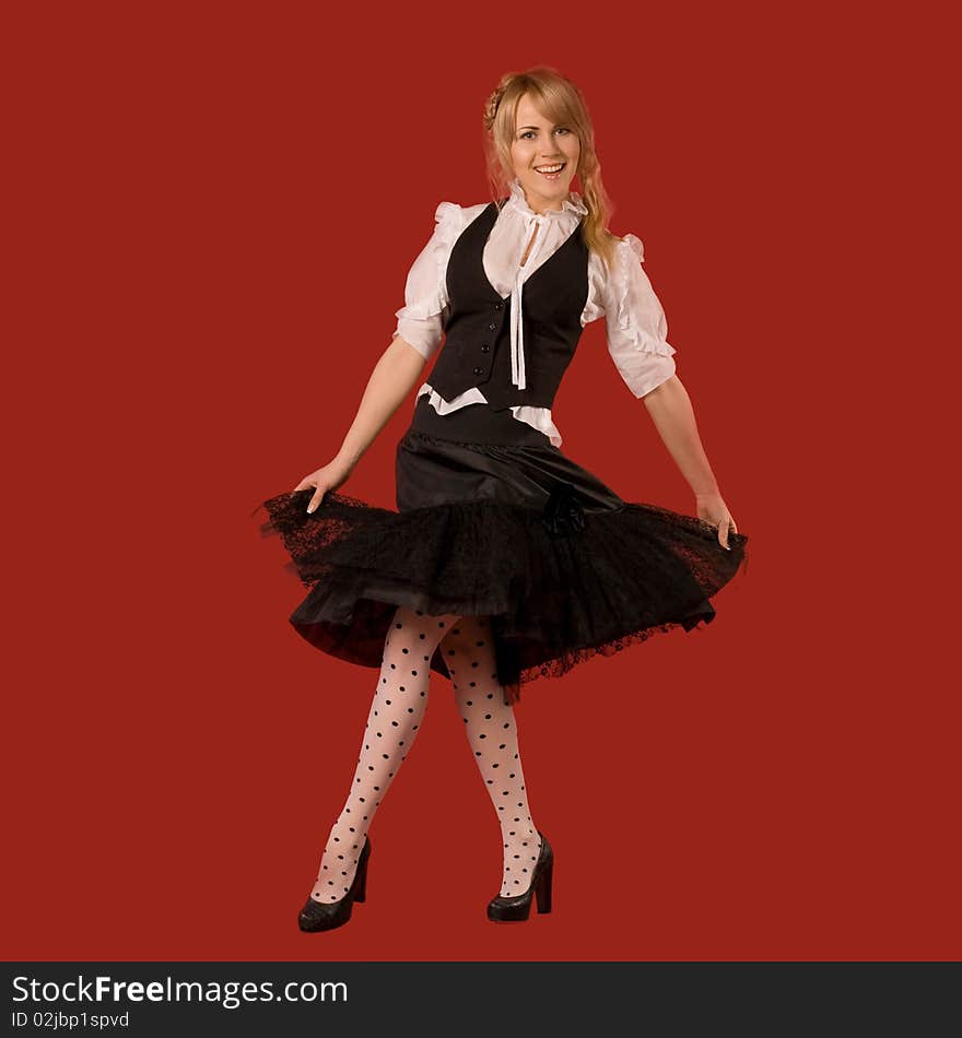 Attractive girl dancing in fashionable clothes - isolated on red