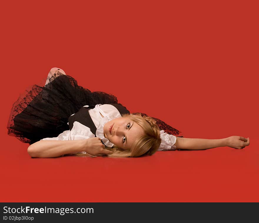 Attractive girl lying on the floor - red background