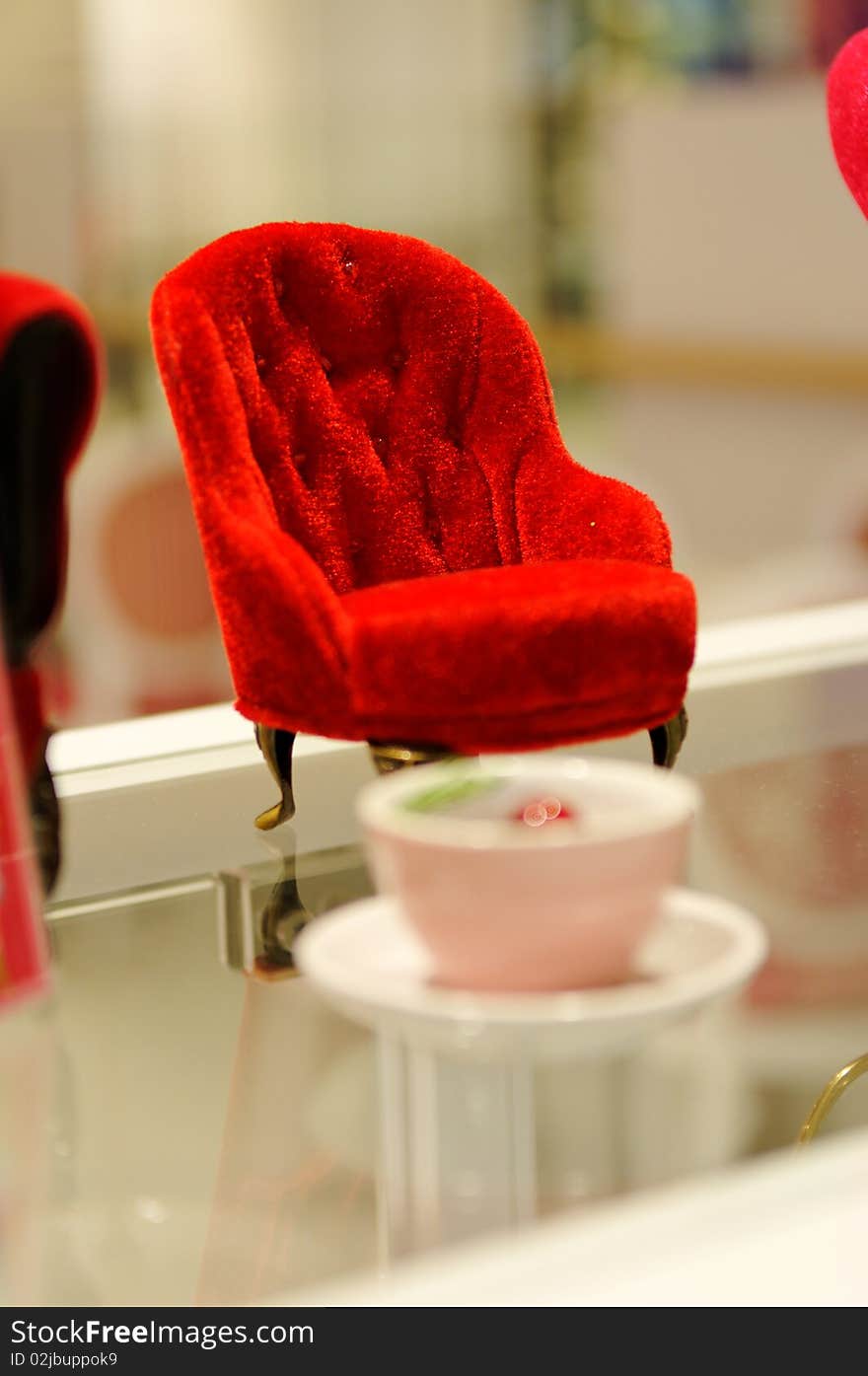 Minature red sofa on glass surface