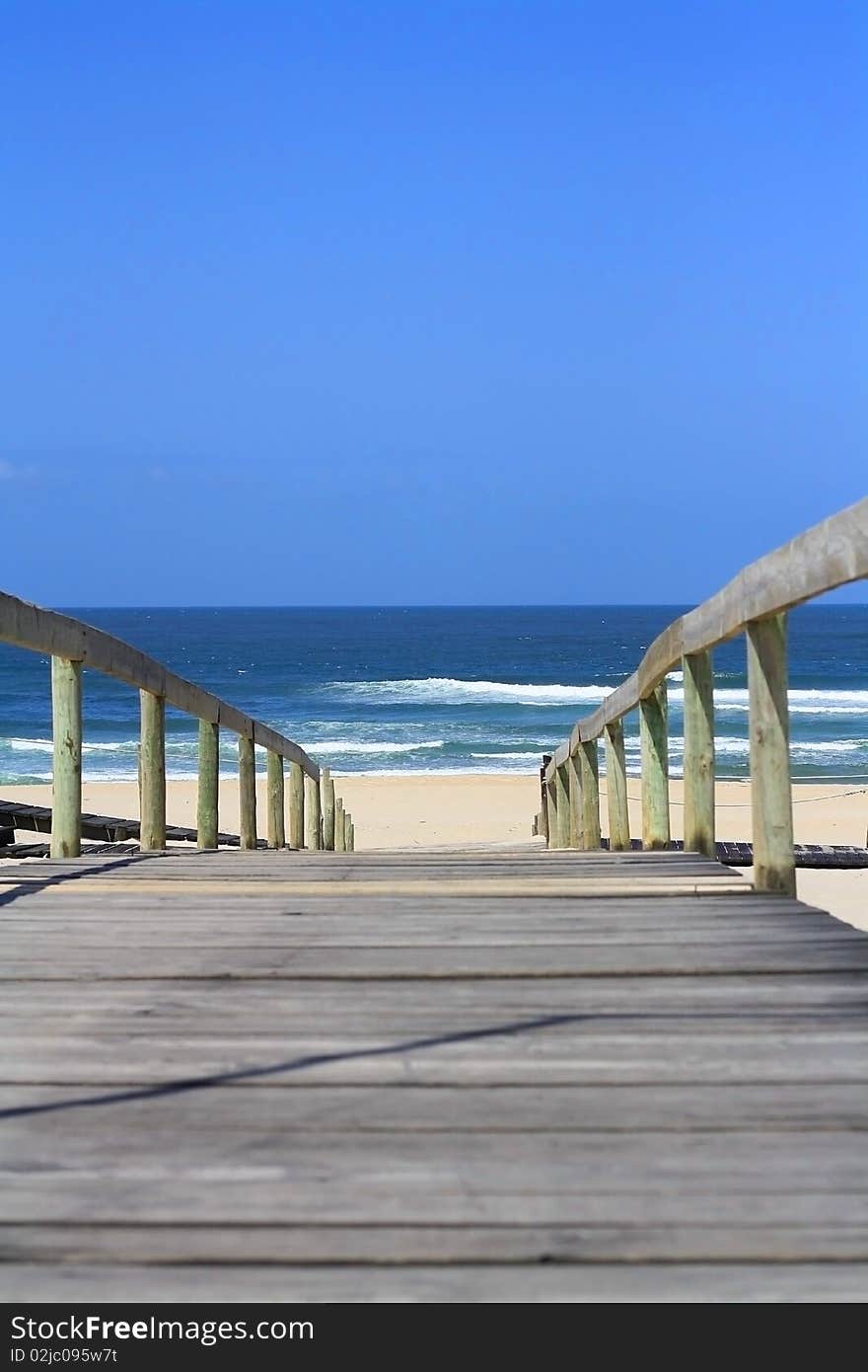 Wooden bridge leading to the sandy shore