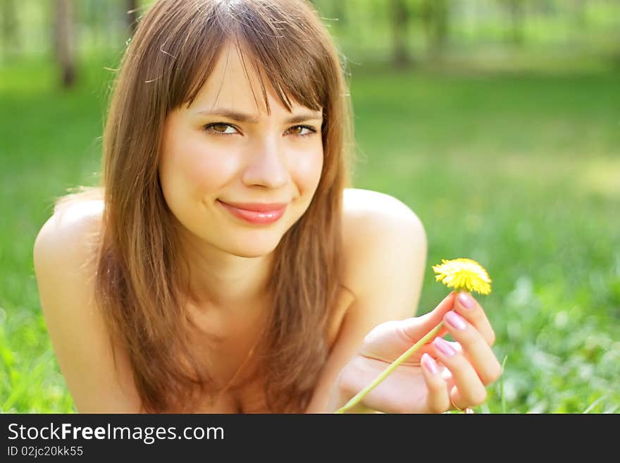 Beautiful young girl lying on grass