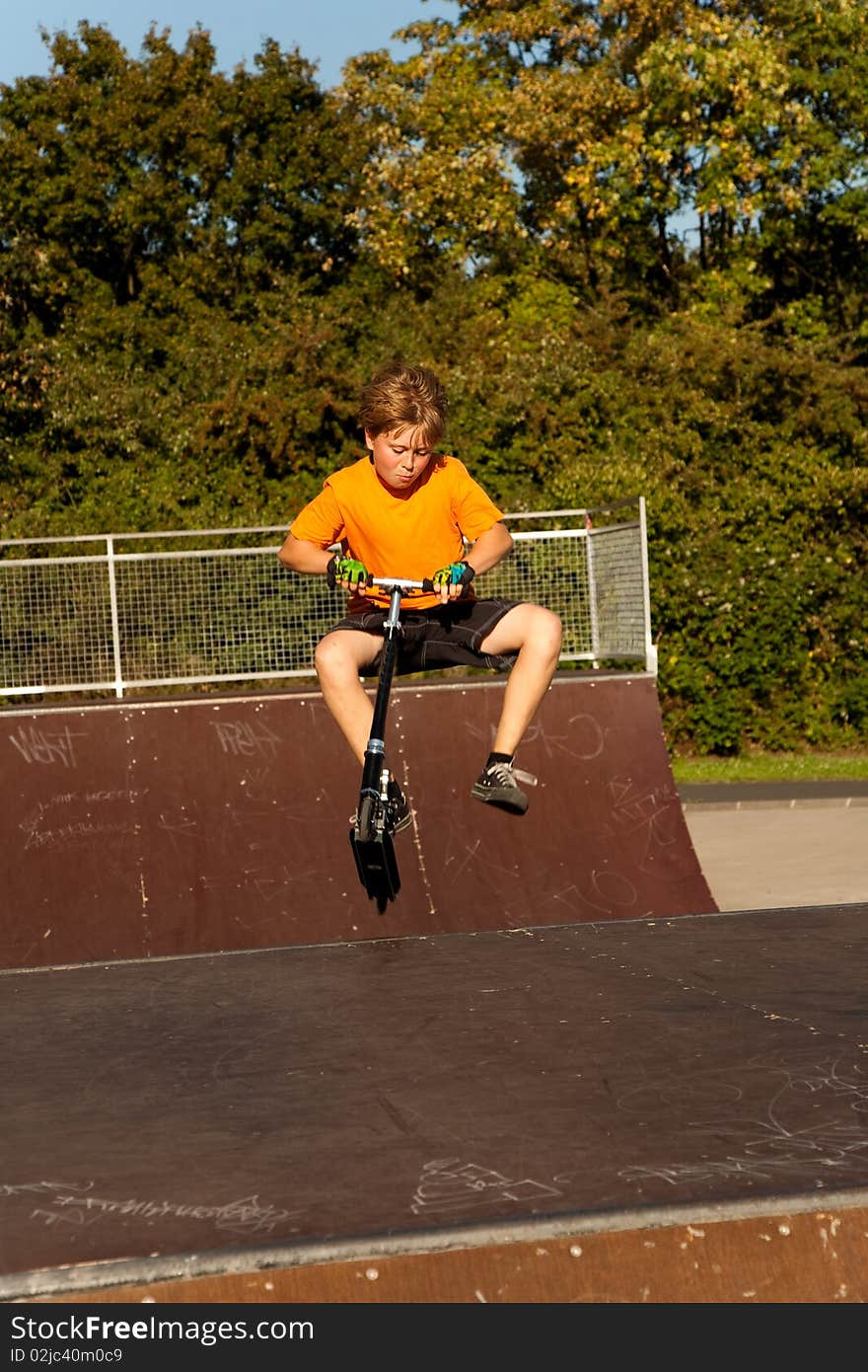 Boy Rides Scooter In A Pipe At A Skate Park