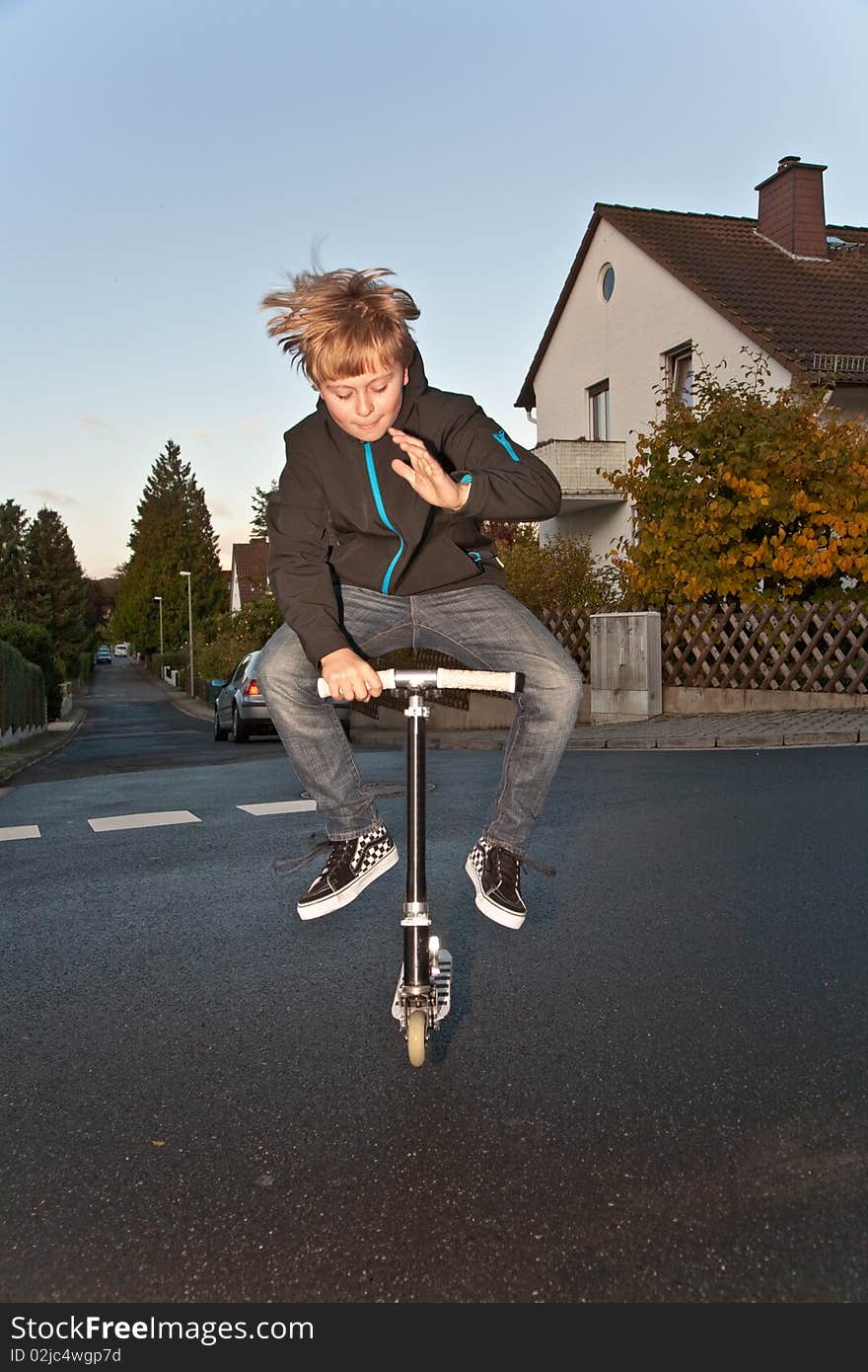 Young Boy Enjoys Riding A Scooter Park