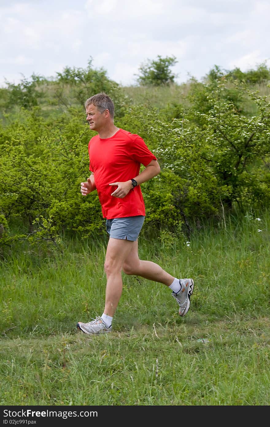 Young man running on a green field. Young man running on a green field