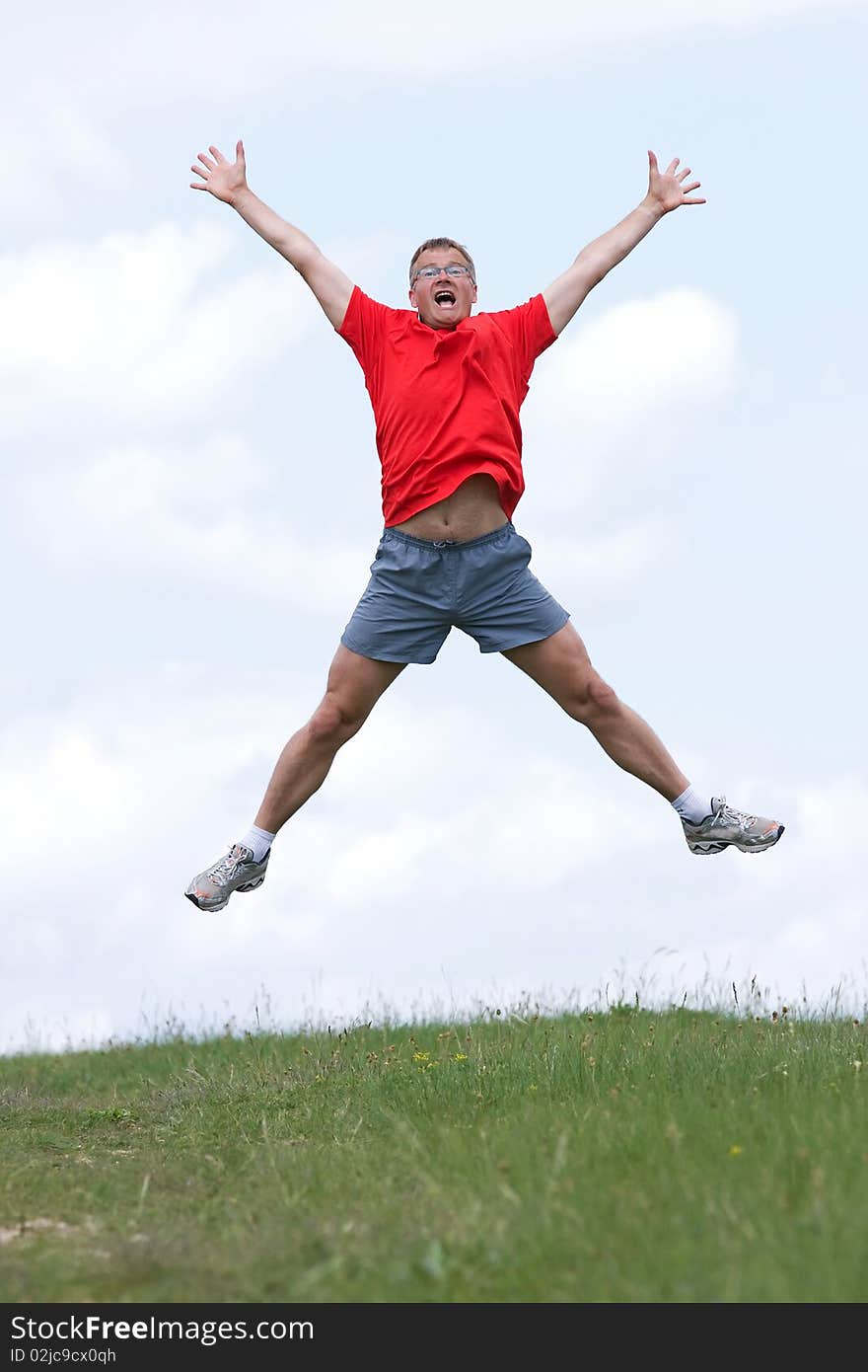 Funny young man high jumping in the field