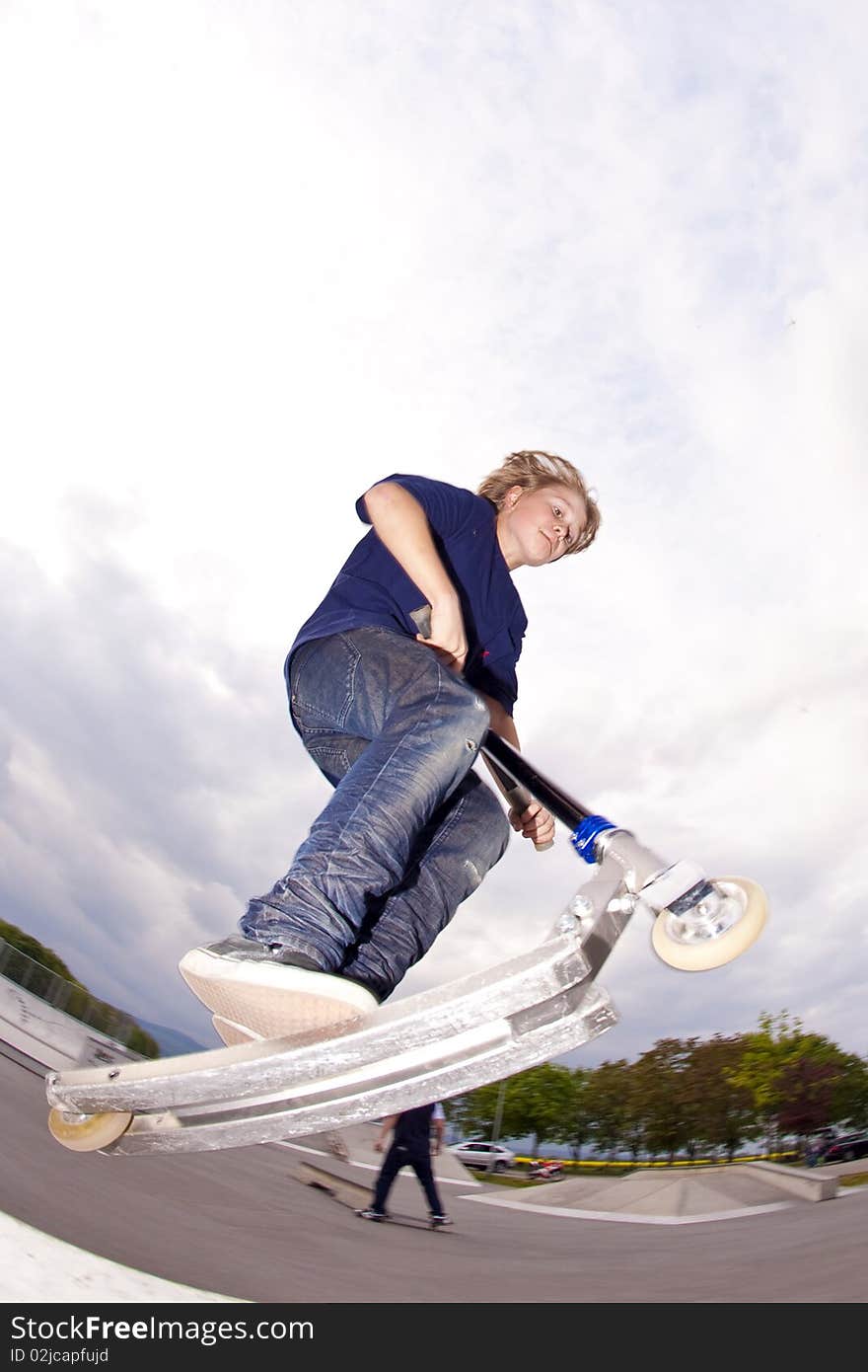 Young boy going airborne with scooter