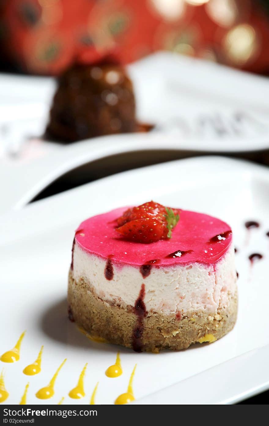 Delicious strawberry chesecake, a real fancy dessert and beautifully presented on a white plate. Delicious strawberry chesecake, a real fancy dessert and beautifully presented on a white plate