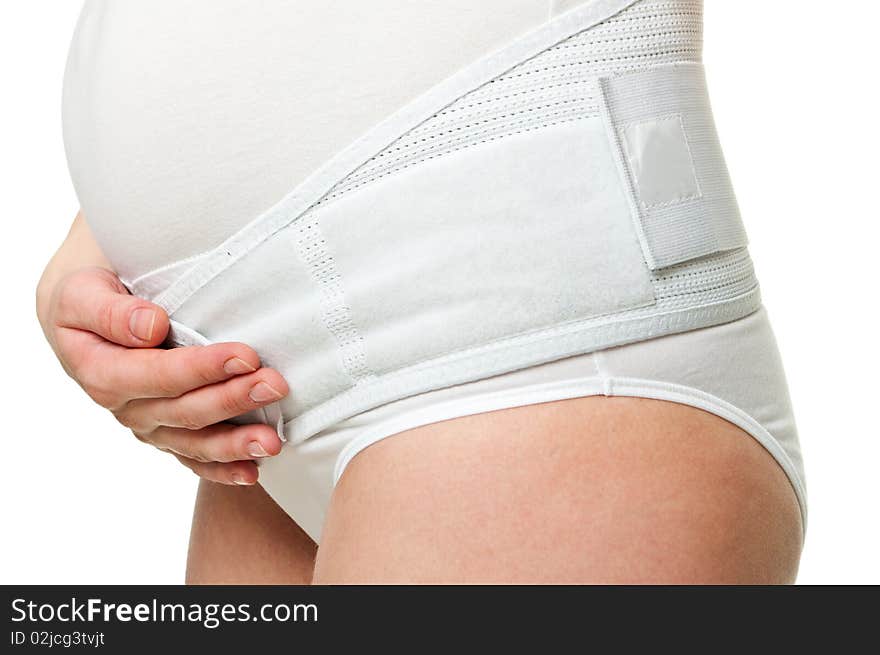 Close-up of a young pregnant woman with corset holding her hands on her tummy