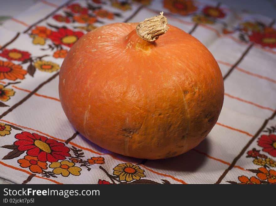 Close view of a orange pumpkin on top of the table.