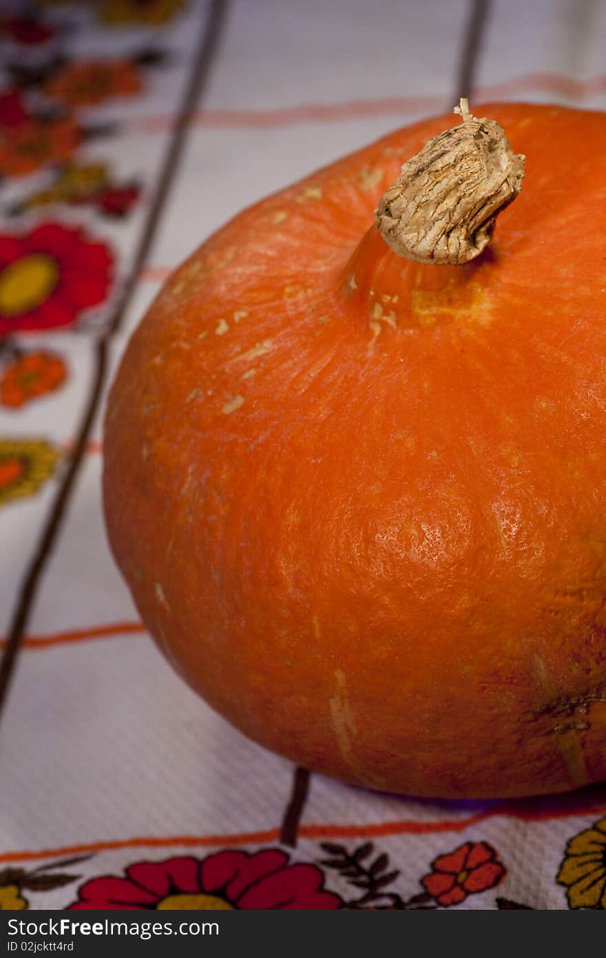 Close view of a orange pumpkin on top of the table.