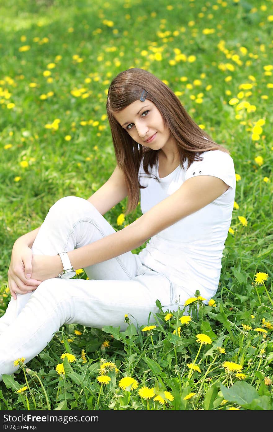 Teenager girl on the glade with dandelions