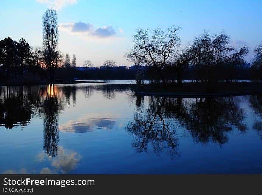 Sunset reflexion into a lake. Beautiful blue sky. Spring sunset