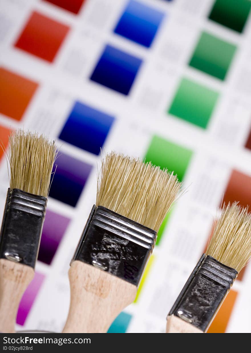 Artistic equipment: paint, brushes and knives on paint background. Artistic equipment: paint, brushes and knives on paint background