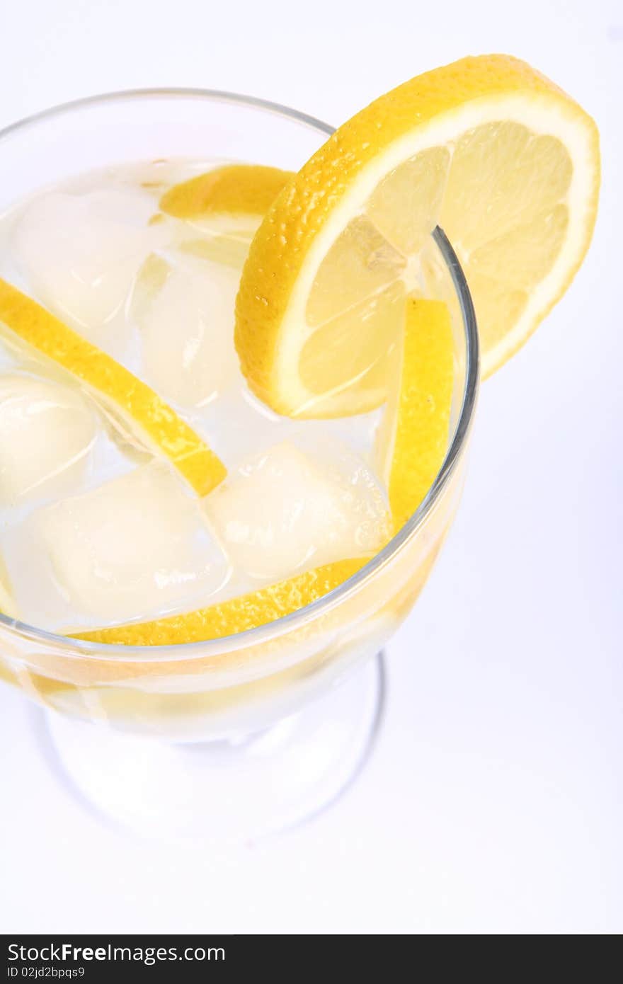 Water with lemon slices and ice in a glass cup on white background. Water with lemon slices and ice in a glass cup on white background