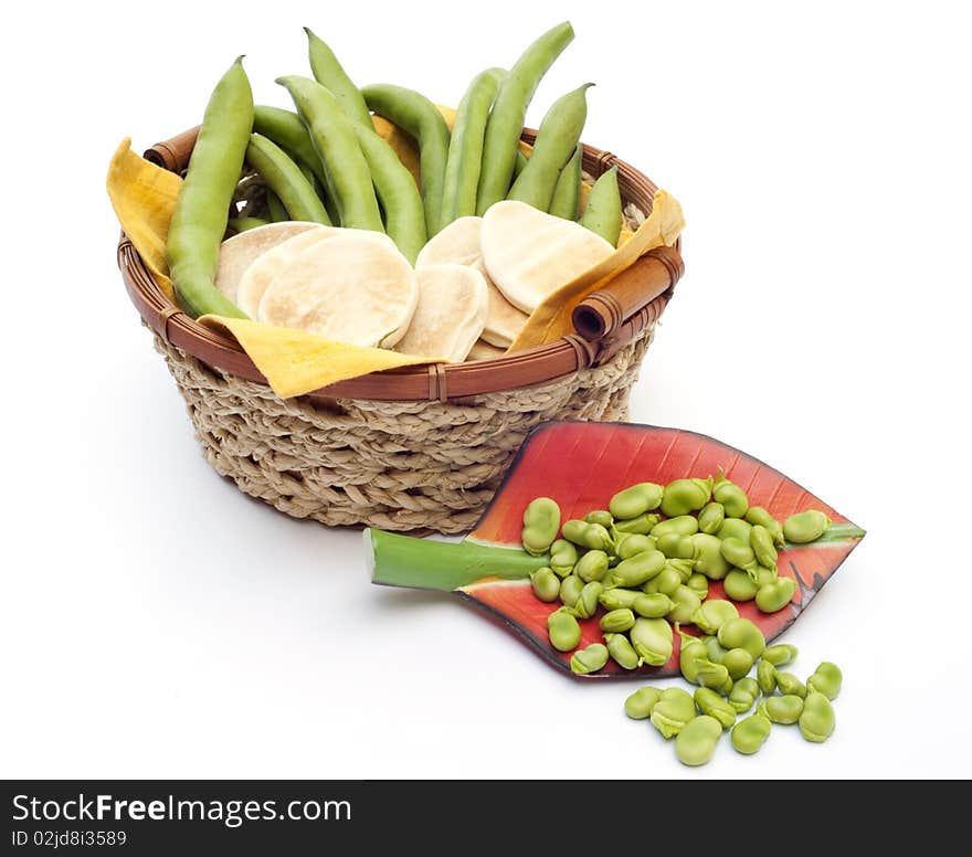 Basket with beans and bread on white background