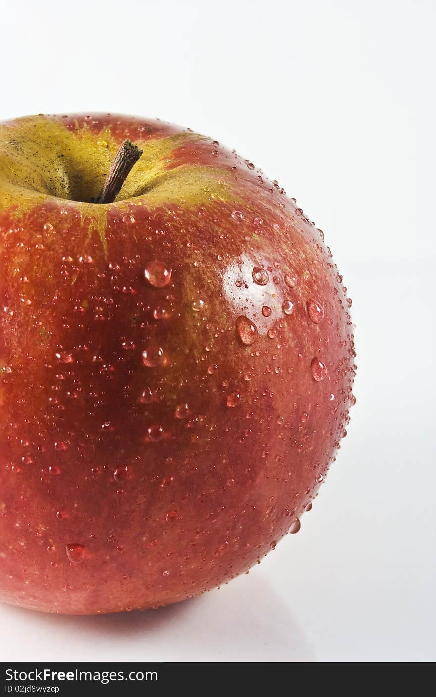 Red apple with drops of water isolated on white background