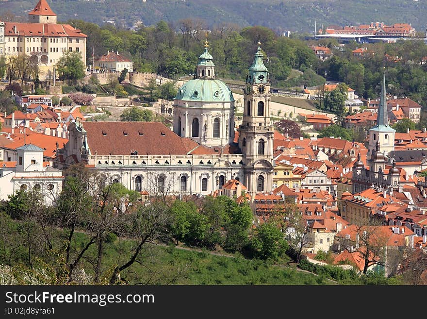 View on Prague´s St. Nicholas´ Cathedral with flowering trees and green grass