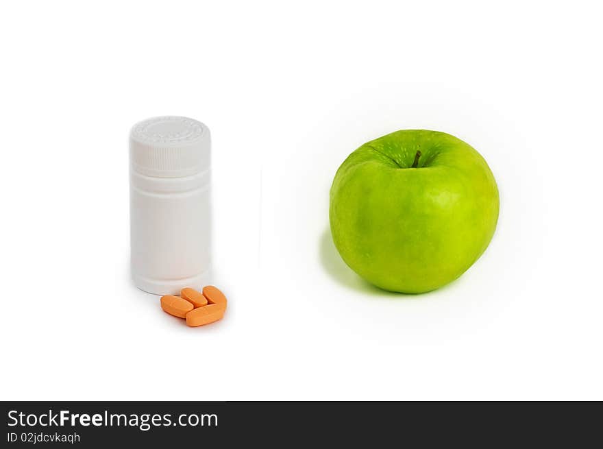 Concept of different vitamin sources - ripe apple or bottle of pills