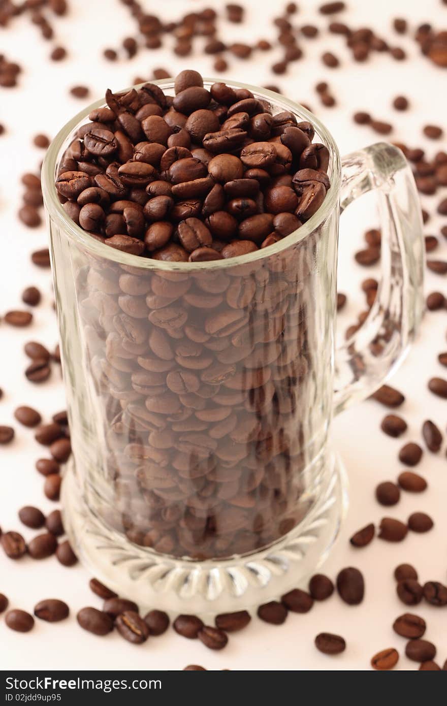 Fresh brown coffee beans in a beer cup