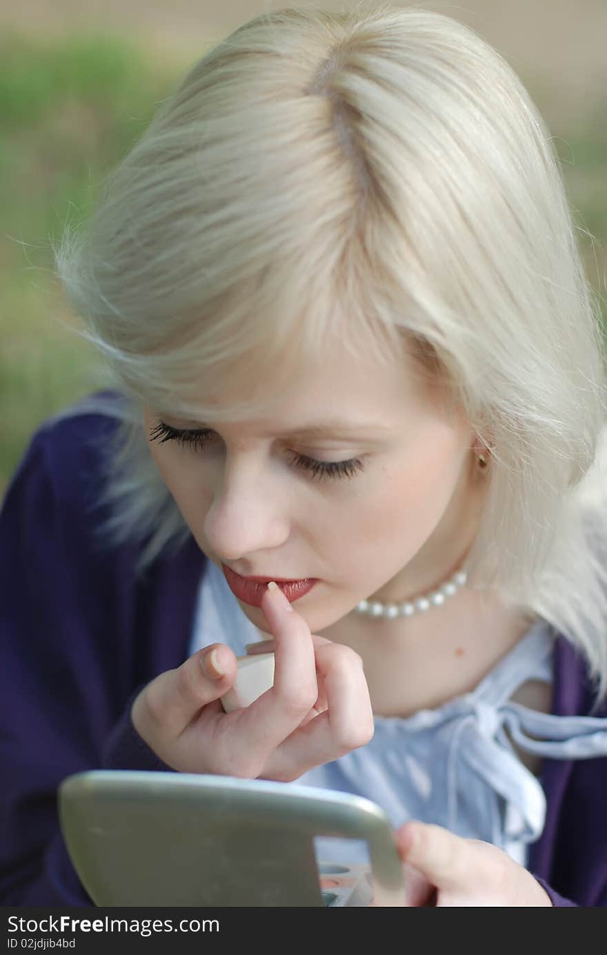 Young woman doing her makeup. Young woman doing her makeup.