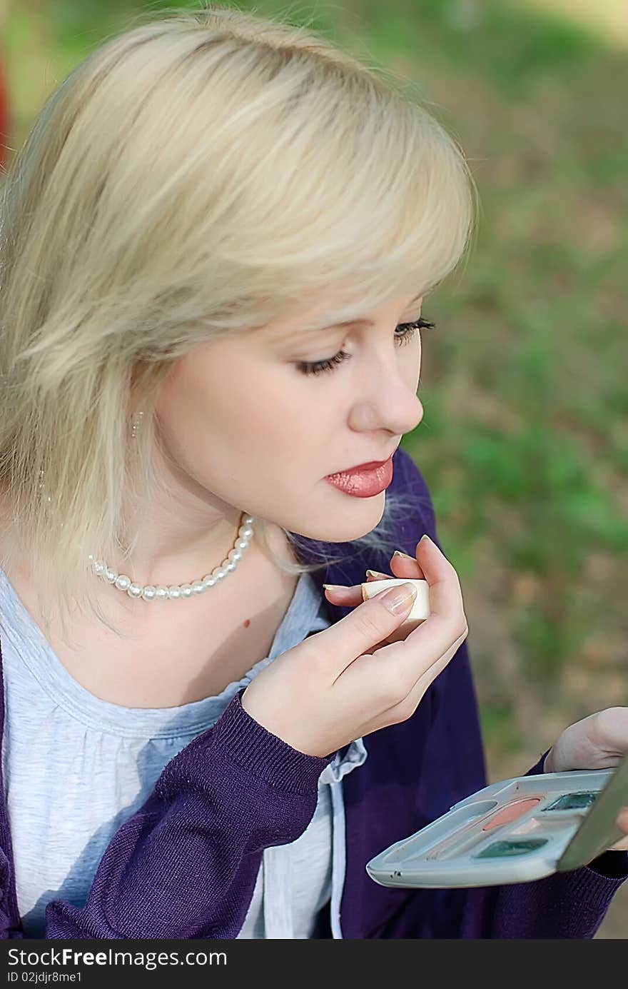 Young woman doing her makeup. Young woman doing her makeup.