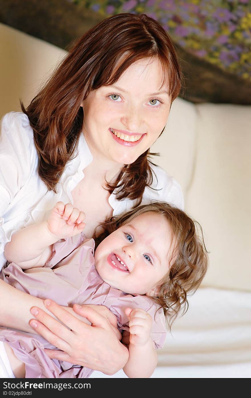 Beautiful mother hugs her 9-months baby-daughter and smiling closeup. Beautiful mother hugs her 9-months baby-daughter and smiling closeup