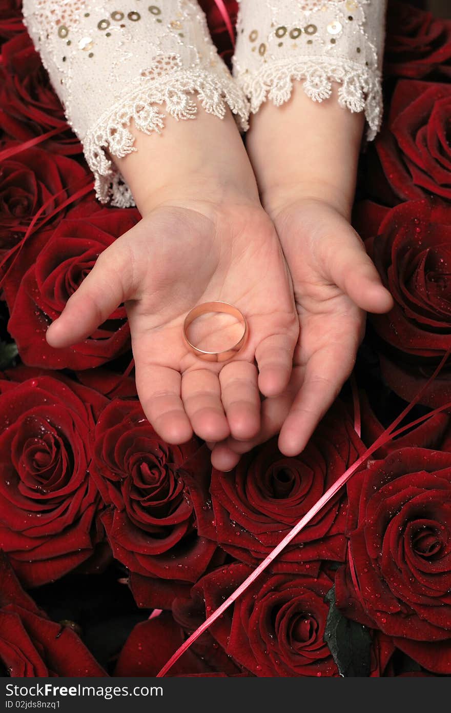 Gold  ring in children hands on ren rosa background