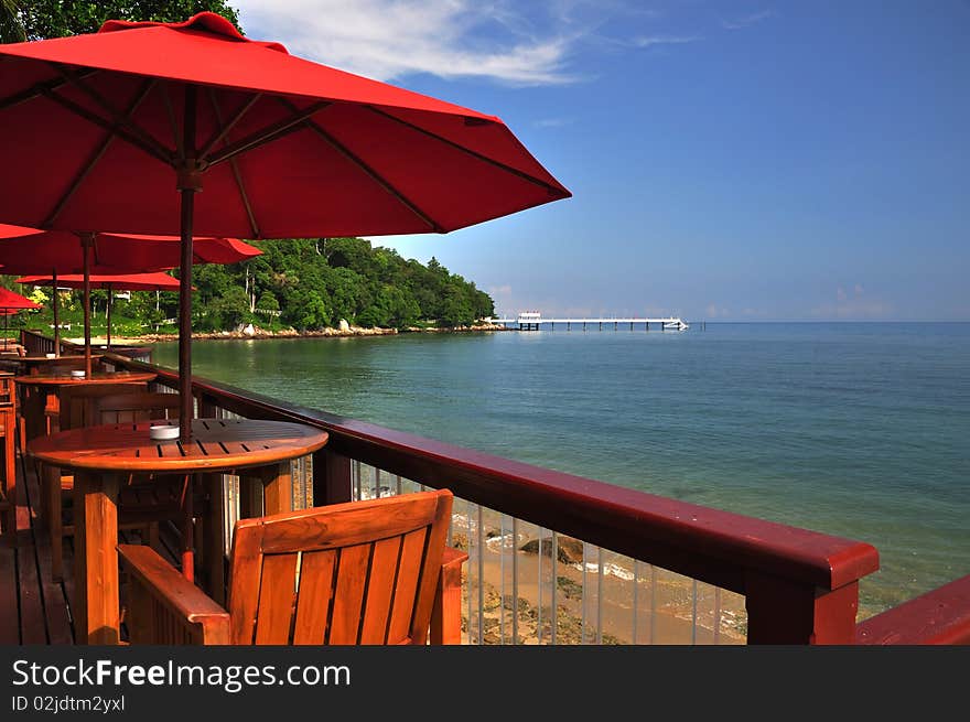 View of chairs and red umbrella on the coast in tropical resort. View of chairs and red umbrella on the coast in tropical resort.