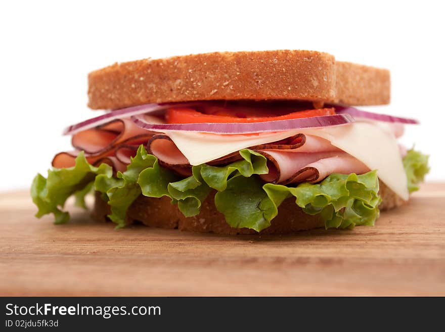 Delicious ham sandwich with whole wheat bread on cutting board. Delicious ham sandwich with whole wheat bread on cutting board