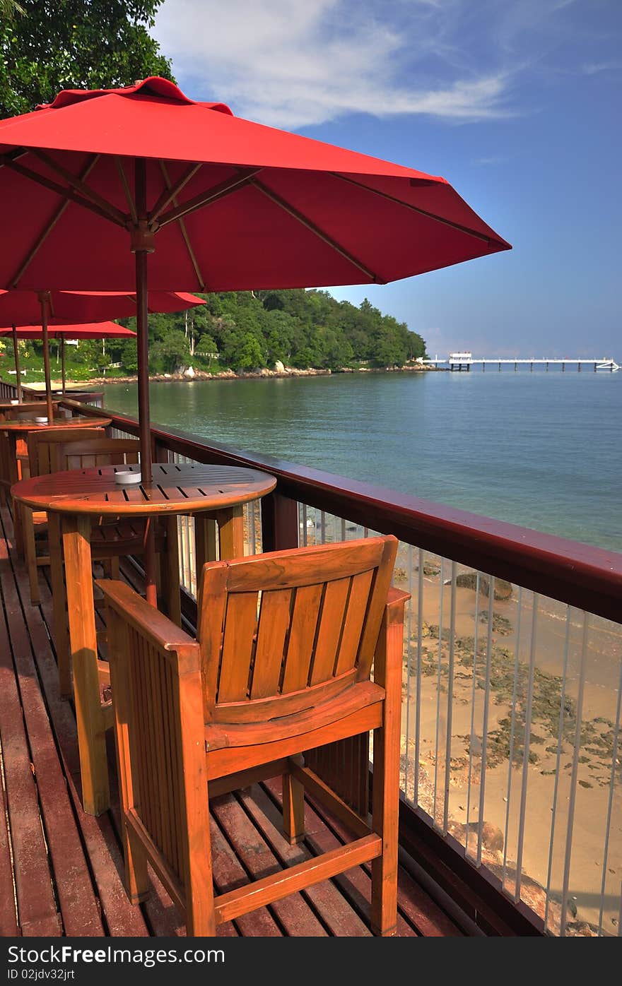 View of chairs and red umbrella on the coast in tropical resort. View of chairs and red umbrella on the coast in tropical resort.